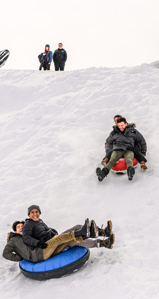 Students sliding down hill on sleds